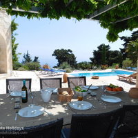 08 The Buoys Villa dining terrace with sea view, and shaded by wisteria.