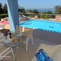 10 Nostalgia poolside dining area with couch, table and chairs.